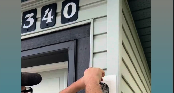 Tolmie Electric technician mounting an exterior electrical outlet on a Calgary home